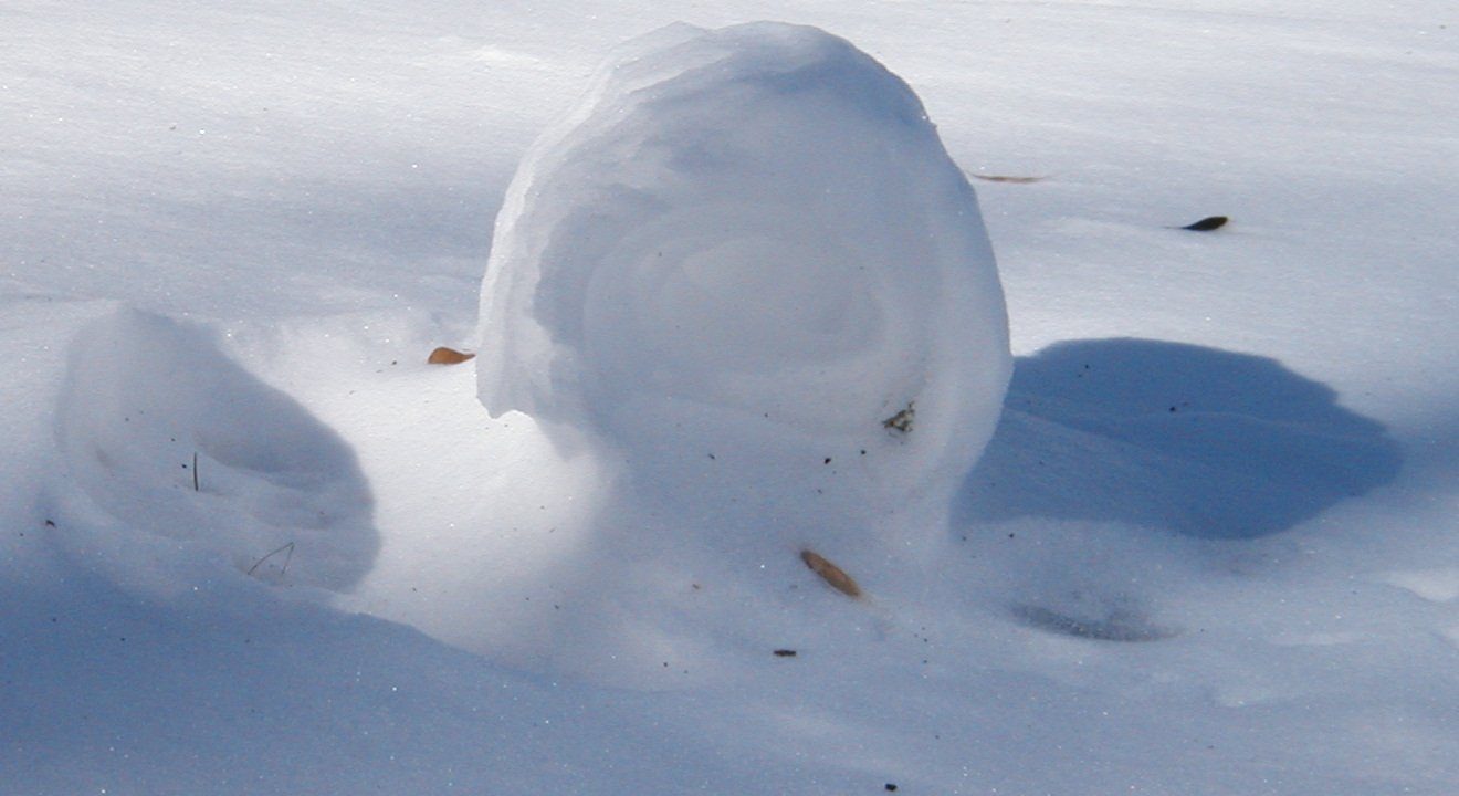 A naturally formed snow roller near Cincinnati with a hollow centre and a trail behind it