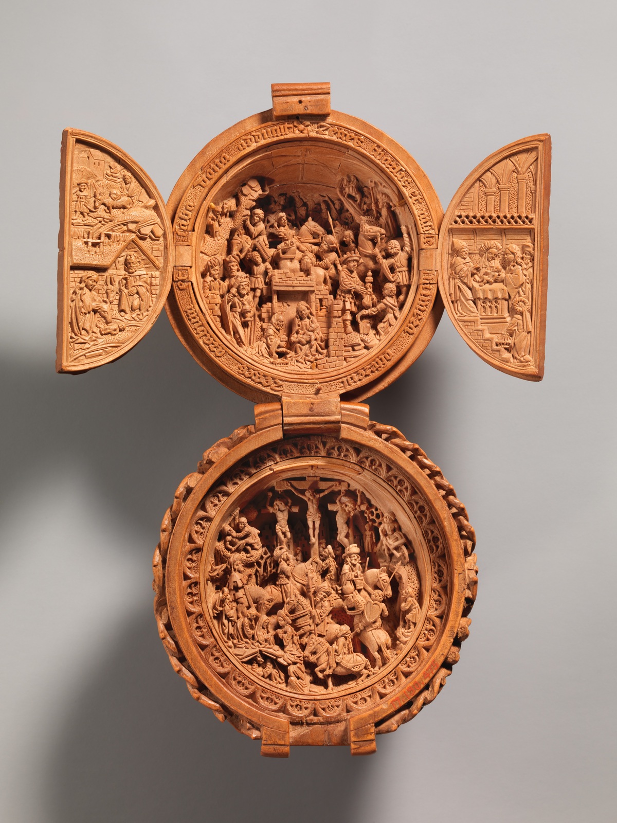 The same prayer bead opened to reveal its miniature carved scenes — The Metropolitan Museum of Art, Open Access / public domain. Boxwood prayer bead 17.190.475. Original photograph; detail crop where indicated.