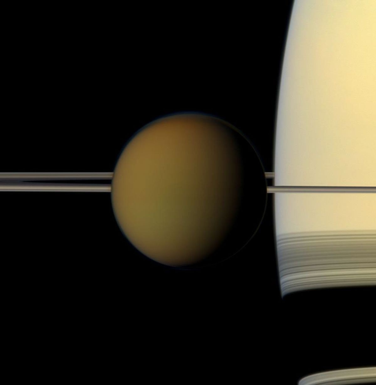 Titan in front of Saturn and its rings in a true-colour Cassini photograph — NASA / JPL-Caltech / Space Science Institute. Cassini true-colour photograph of Titan in front of Saturn and its rings.